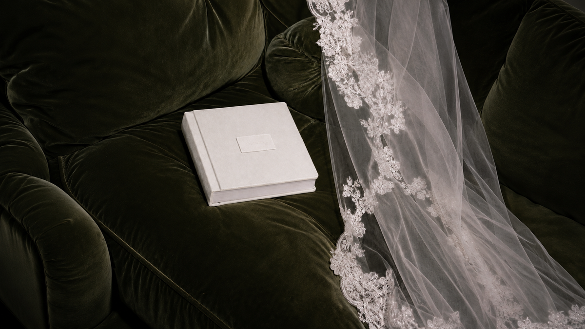 A wedding album resting beside a couture bridal veil